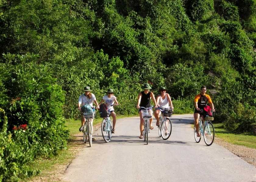 Cycling on the historic Ho Chi Minh Trail in Phong Nha Ke Bang National Park surrounded by limestone cliffs.