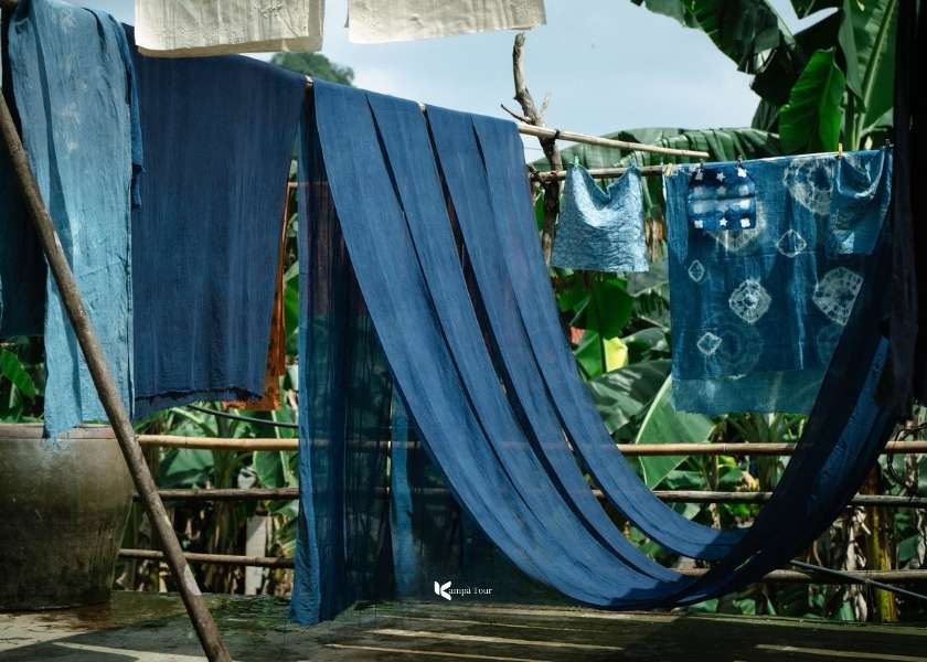 The blue-dyed fabrics are drying in the warm sun.