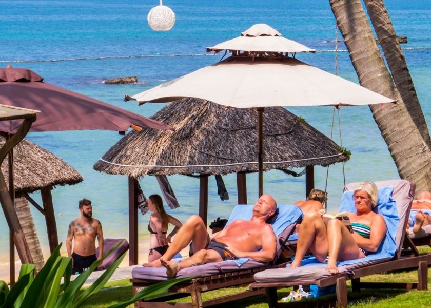 Lying stretched out, sunbathing on the blue beach.