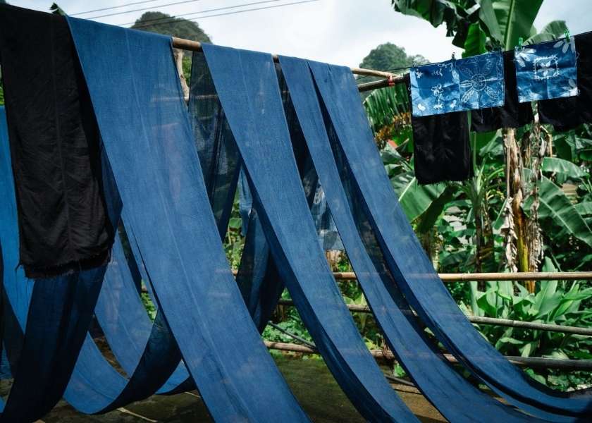 The blue-dyed fabrics are drying in the sun.