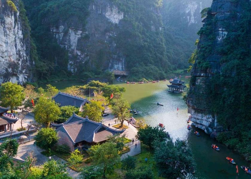 Scenic boat route through limestone mountains and traditional temples in Trang An, Ninh Binh.