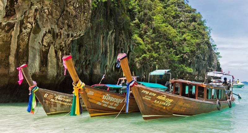 Longtail boats anchored in the crystal-clear waters of Phi Phi Islands, a tropical haven near Phuket.
